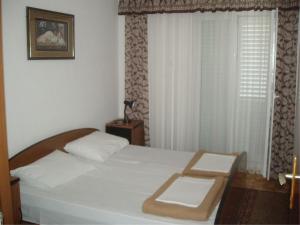 斯拉诺Apartments with a parking space Slano, Dubrovnik - 12576的卧室配有白色的床和窗户