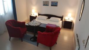 库希斯特Apartments by the sea Viganj, Peljesac - 12564的一间卧室配有一张床和两张红色椅子