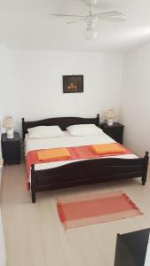 库希斯特Apartments by the sea Viganj, Peljesac - 12564的一间卧室配有一张带橙色和橙色床单的大床