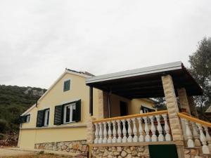 奈维丹Secluded holiday house Cove Nevidjansko Polje, Pasman - 12806的一座带门廊和白色围栏的房子