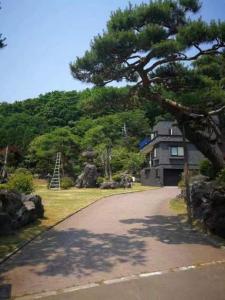 札幌Senougen的车道前有树的房子