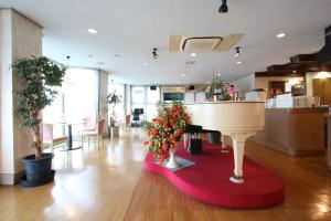 指宿市Business Hotel Furusato的一间在红色地毯上摆放着钢琴和鲜花的房间