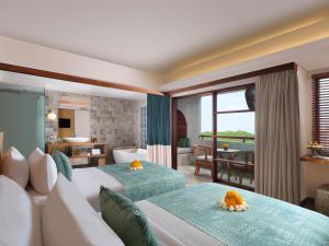 努沙杜瓦Amnaya Resort Nusa Dua的一间带两张床的卧室和一间客厅