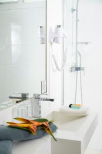 努美阿博里瓦奇酒店的白色的浴室设有水槽和淋浴。