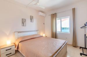 普利兹巴Apartments by the sea Karbuni, Korcula - 13217的一间卧室设有一张大床和一个窗户。