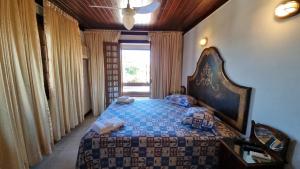 布希奥斯Casa 10 suítes, até 64 pessoas, Praia Ferradura的一间卧室配有一张带蓝色棉被的大床