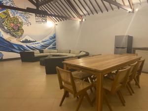 坎古Nami Surf Stay的一间带木桌和椅子的用餐室