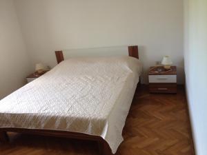 乌格连Apartments by the sea Muline, Ugljan - 12533的一间卧室配有一张床和两个带灯的床头柜