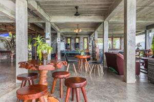 涛岛Deishaview Jungle Hostel的一间餐厅,在房间内配有木凳和桌子