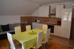 扎达尔Apartments with a parking space Zadar - 13534的厨房配有桌椅