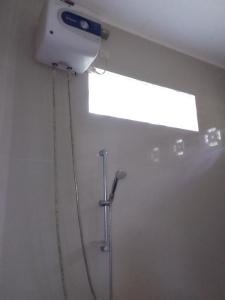 克里穆图SHILA GUEST HOUSE的带淋浴的浴室,天花板上配有灯