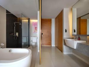 芭东海滩The Kee Resort & Spa的带浴缸、盥洗盆和卫生间的浴室