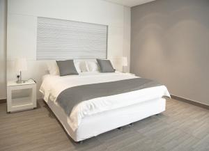 利雅德拉法公寓式酒店的卧室设有一张白色大床和一扇窗户。