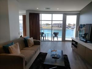 沃拉鲁Apartment 3 Wallaroo Marina的带沙发、电视和桌子的客厅