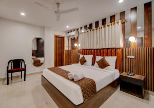 古瓦哈提Hotel Sai Rain Tree的一间卧室配有一张大床和一张红色椅子