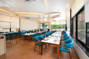 奥兰加巴德Enrise by Sayaji Aurangabad的一间配备有桌子和蓝色椅子的用餐室