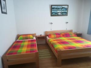 洛克维Apartments with a parking space Lokve, Gorski kotar - 15061的一间卧室配有两张带彩色毯子的床