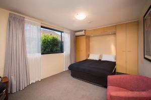 悉尼Drummoyne Furnished Apartments的卧室配有床、椅子和窗户。