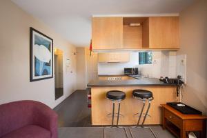 悉尼Drummoyne Furnished Apartments的厨房配有柜台和2个酒吧凳
