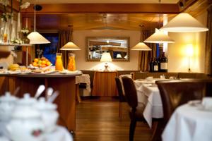 圣安东阿尔贝格洛萨蔷薇高级酒店的餐厅设有桌椅和镜子