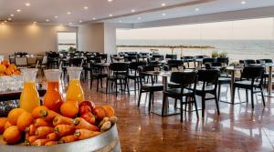 特拉维夫特拉维夫海滩皇冠假日酒店的一间设有桌椅的房间和一碗水果