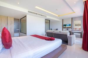 芭东海滩Paripas Patong Resort - SHA Extra Plus的卧室配有一张白色大床和一张书桌