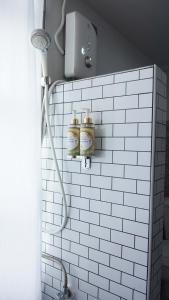 Ban Bang Kho维斯塔格酒店的浴室的白色瓷砖墙上装有三罐
