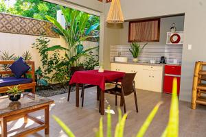曼巴豪巴莱山白白公寓的厨房以及带红色桌椅的起居室。