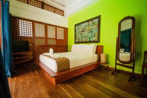 曼巴豪巴莱山白白公寓的一间卧室配有一张带绿色墙壁和镜子的床