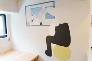 东京ART HOTELS SHIBUYA的卧室,墙上挂着一个人坐在椅子上的壁画