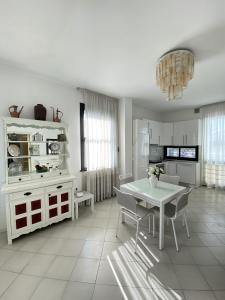 里乔内Villetta Trieste-Flexrent Abissinia的白色的厨房配有白色的桌子和椅子