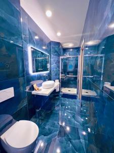 巴韦诺La Tana Del Ludo的蓝色的浴室设有2个水槽和淋浴。