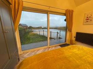Crawshaw BoothCedar Lodge的一间卧室设有大窗户,享有水景