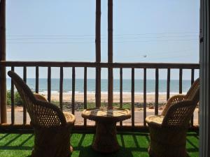 马尔万Chivarin Resorts的一个带两把椅子和一张桌子的阳台以及海滩
