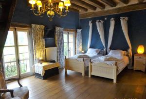 MalétableMoulin de Sévoux的一间卧室配有两张床和吊灯。