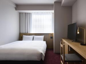 札幌hotel androoms Sapporo Susukino的酒店客房,配有床和电视