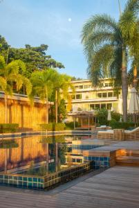 拉威海滩Selina Serenity Rawai Phuket的一座带游泳池、棕榈树和大楼的度假村