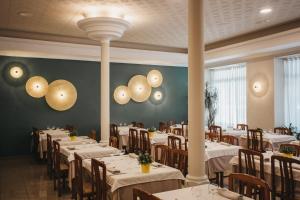 里贝斯的弗里瑟加泰罗尼亚里伯斯德福瑞泽酒店的用餐室配有白色的桌子和木椅