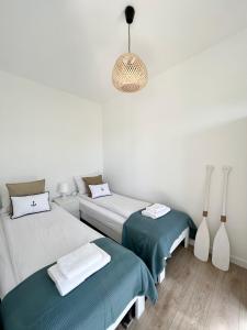 萨比诺瓦Resto domki letniskowe的配有两张床和吊灯的房间