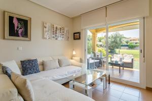 阿利坎特Chalet Bonalba Golf的带沙发和玻璃桌的客厅