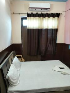 珀勒德布尔Suresh Guest House & Hotel By WB Inn的窗户和床筒的房间里一张床位