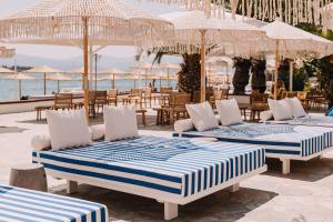 埃雷特里亚Brown Beach Evia Island, All Inclusive in Eretria, a member of Brown Hotels的一组床,坐在靠近大海的庭院