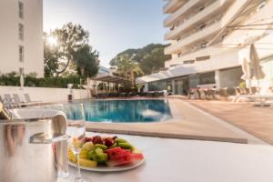 帕尔马海滩Hotel Principe Wellness&Spa的池边桌子上的一盘水果