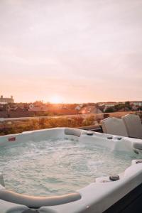 奥拉迪亚Hotel Glory的阳台上的热水浴池,享有日落美景