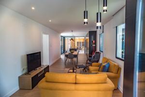蓬塔德尔加达Populo's Place的客厅配有两张黄色的沙发和一台电视