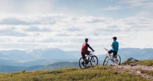 高尔Golsfjellet - Bualie, milevis med sykkelveier, fiske og vannaktivitet, ski inn/ut til alpinanlegg og langrennsløyper.的山丘顶部有两辆骑车