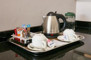 哈博罗内Regent Select Hotel的茶壶和茶杯盘