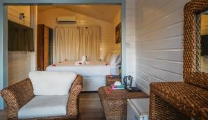 莫罗尼Golden Tulip Grande Comore Moroni Resort & Spa的配有床、两把椅子和镜子的房间