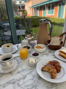 圣安东尼奥德阿雷科Hotel Draghi的餐桌上摆放着早餐食品和咖啡盘