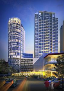 泗水Hotel Ciputra World Surabaya managed by Swiss-Belhotel International的一座大型建筑,前面有汽车停放